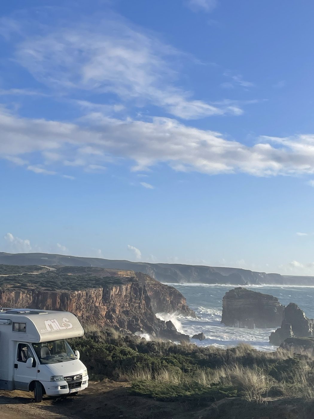 The camper van parked on a clifftop above the ocean